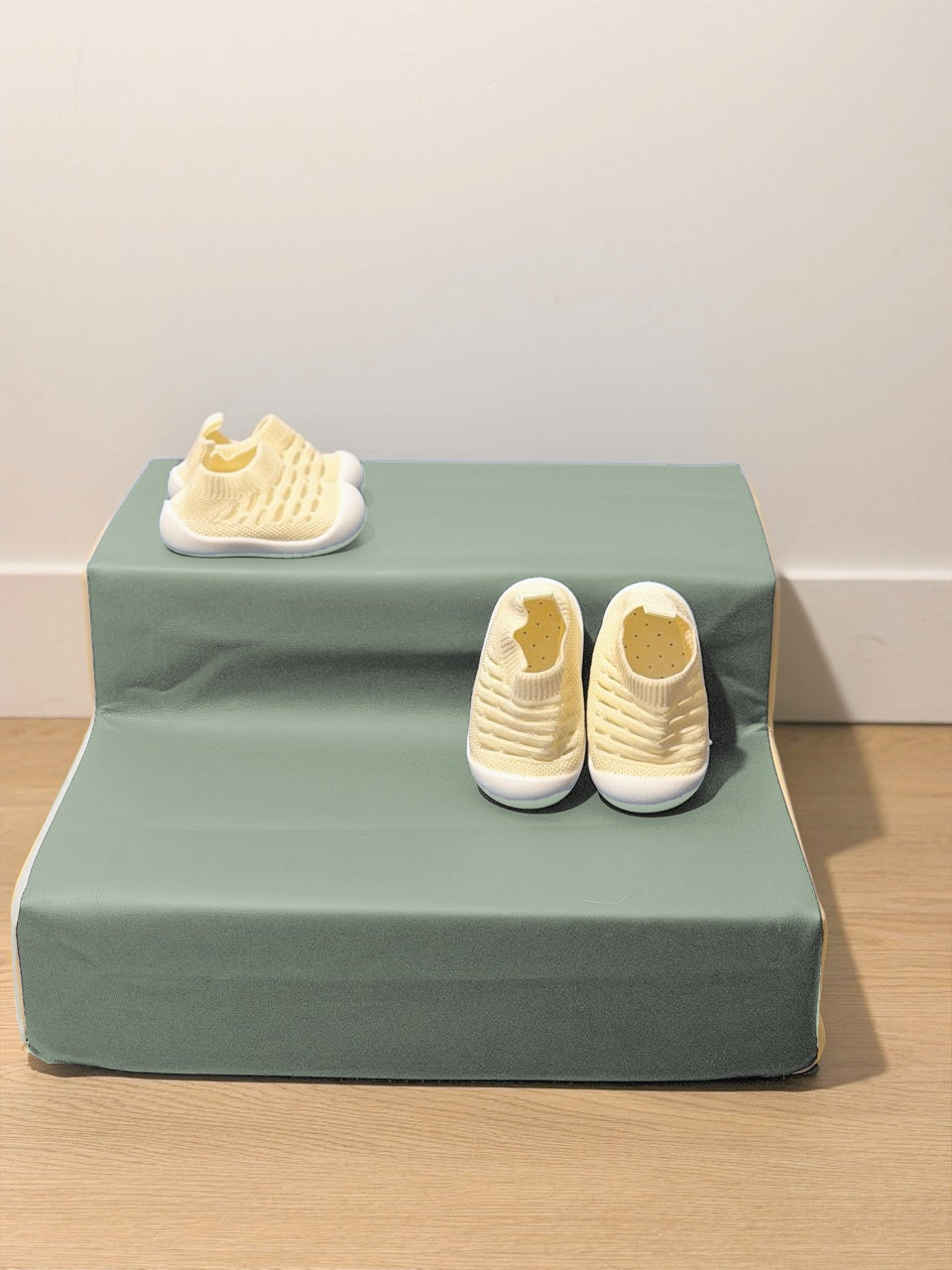 Chaussons bébé en maille Vanille douce, deux paires sur un support sauge.