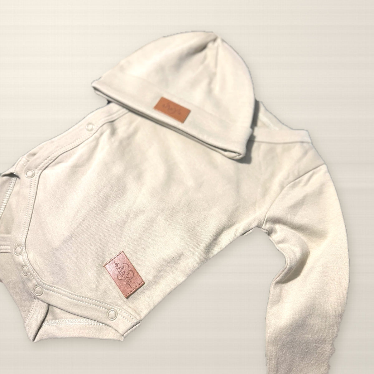 Détail du cache-couche kimono Tout Doux™ et étiquette en cuir A&Y, vraie photo / Tout Doux™ kimono bodysuit detail with A&Y leather tag, real photo