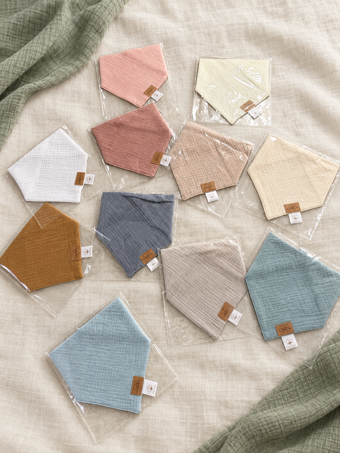 Bandanas MINUS unis emballés individuellement, dans un assortiment de couleurs douces.