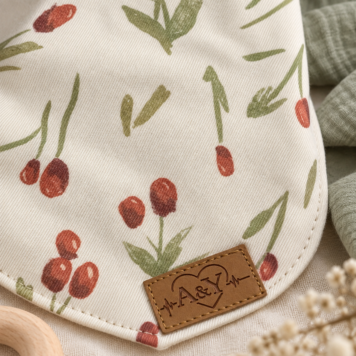 Close-up of the red floral cotton and A&Y label on the MINUS bandana bib.