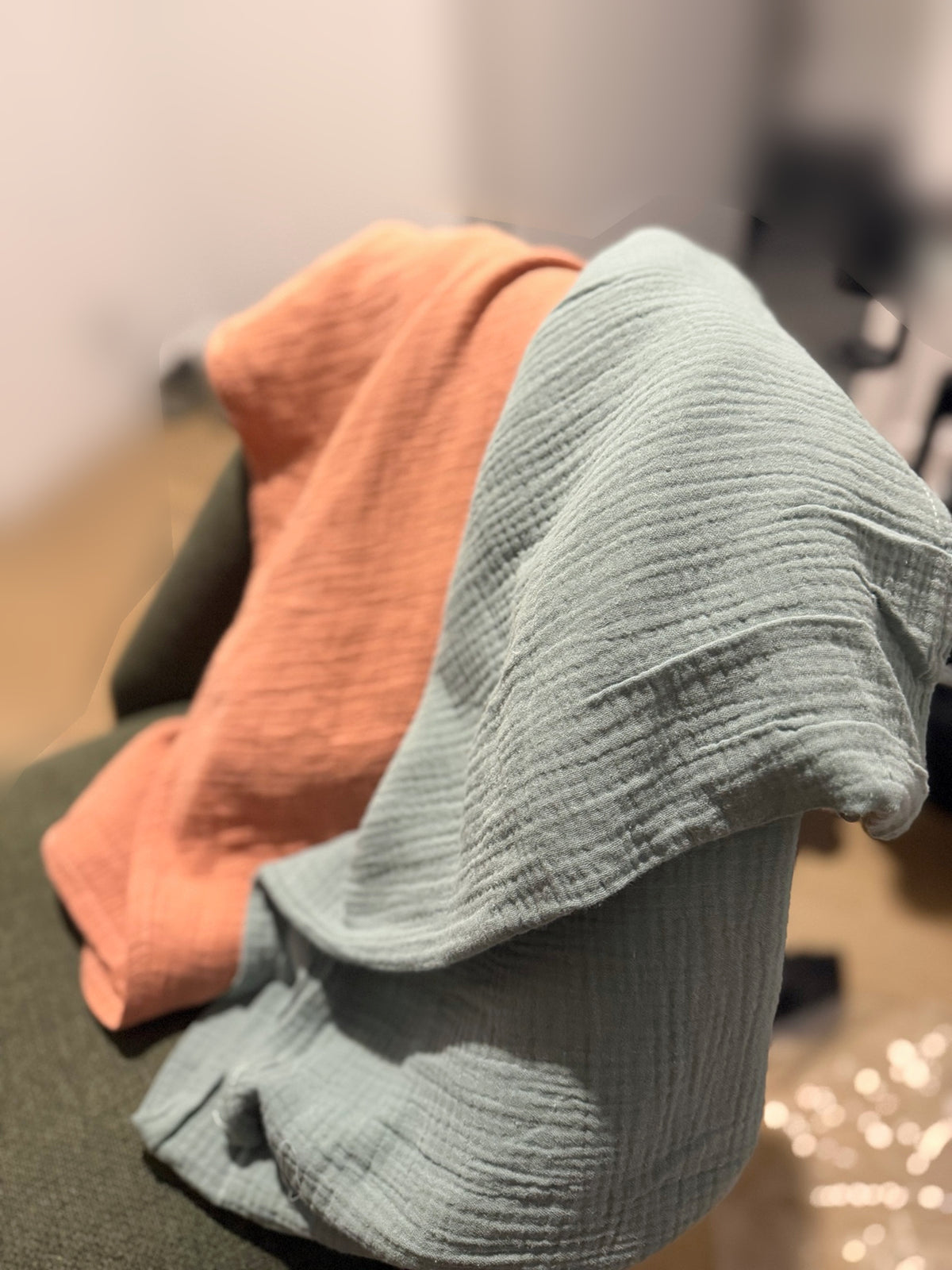 Détail de la texture gaufrée de la couverture en mousseline bleu-gris, avec le modèle terracotta en arrière-plan.