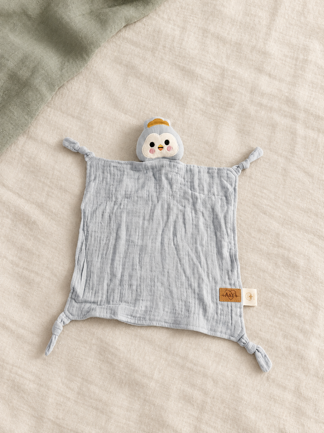 Doudou MINUS pingouin bleu-gris, corps en mousseline et quatre coins noués.