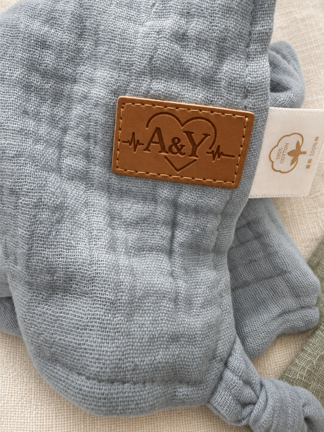 Détail de la signature A&Y et du tissu en mousseline du doudou MINUS.