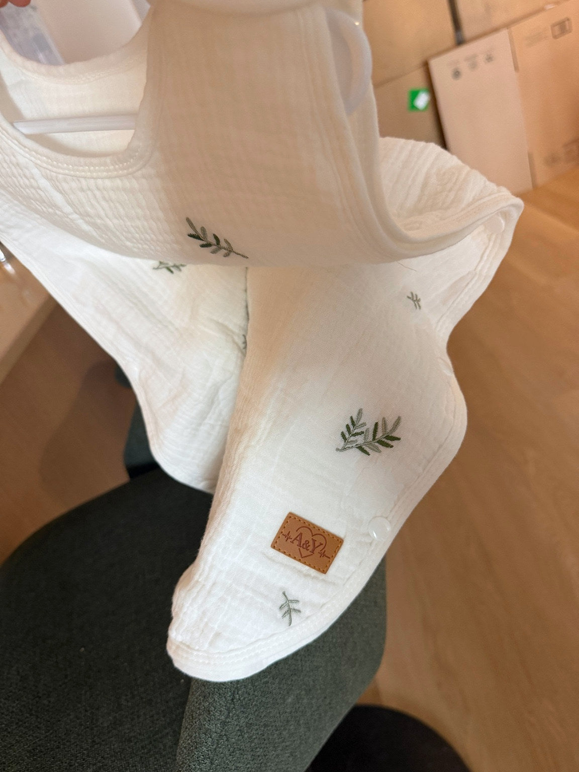 Détail de la gigoteuse MINUS à motif feuillage, ouverte pour montrer les boutons-pression et la signature A&Y.